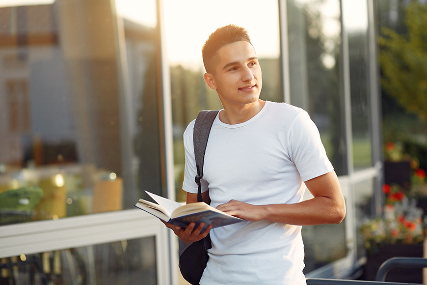 Student in a university campus with a books
