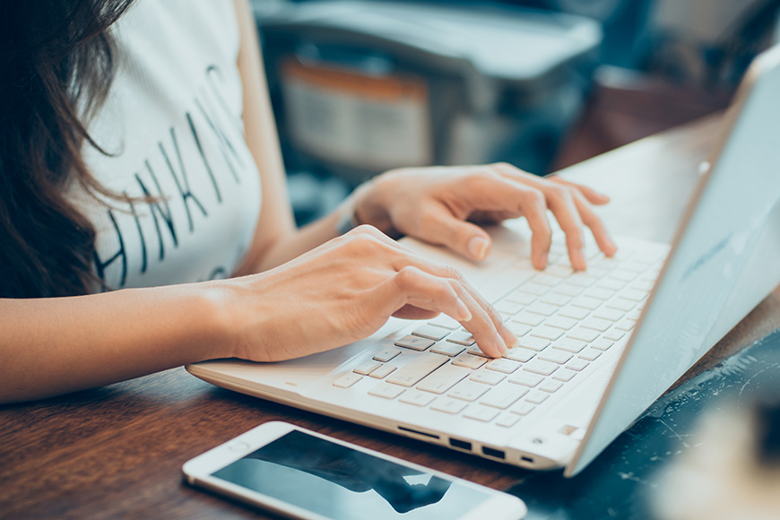 woman's hands busy working on her laptop
